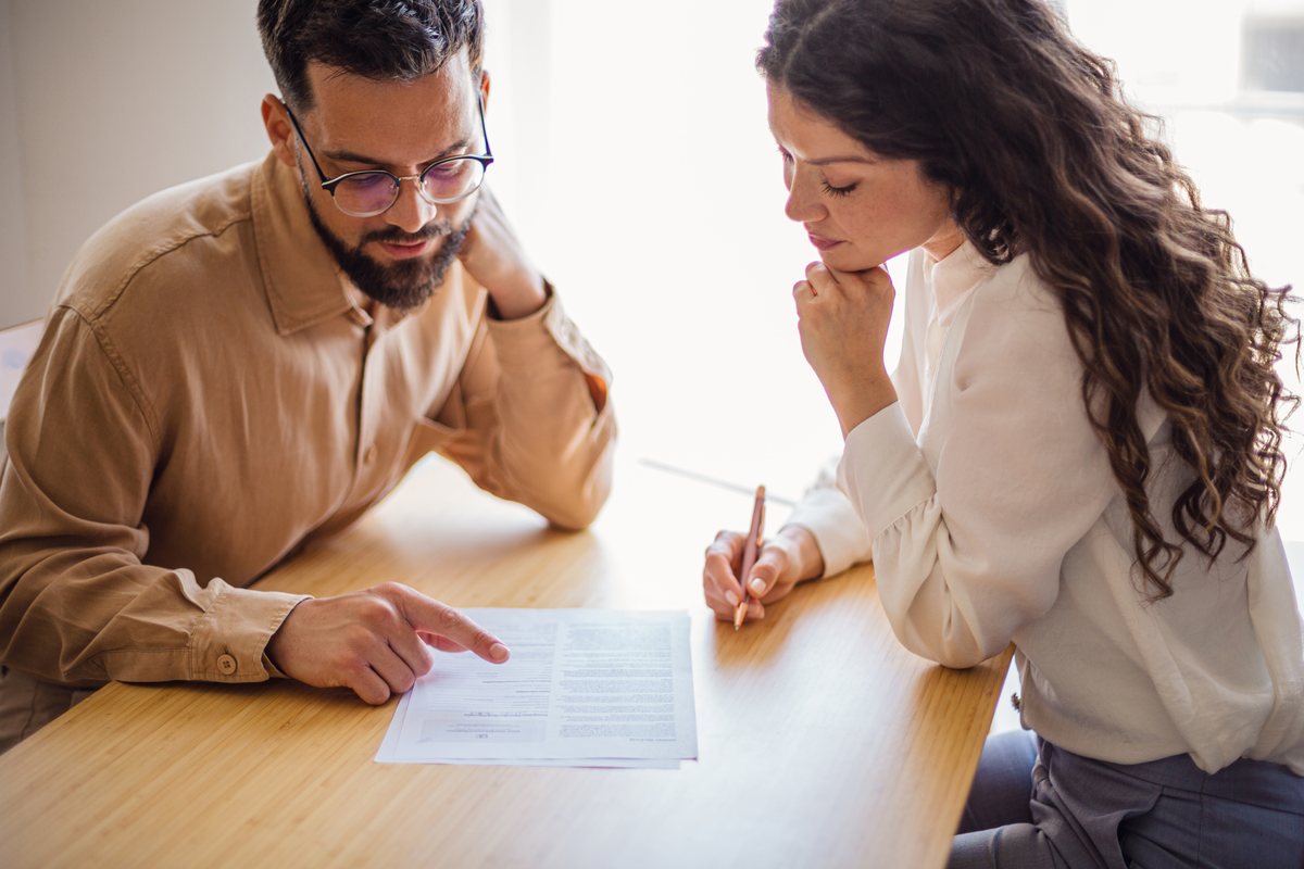 An adviser and a college finance manager going through VAT records