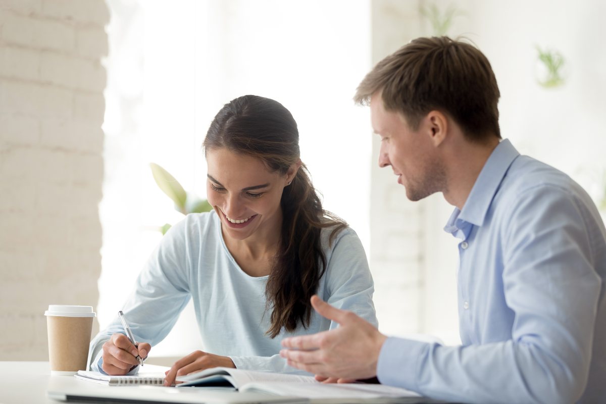 A tutor working through a problem with a student at a table